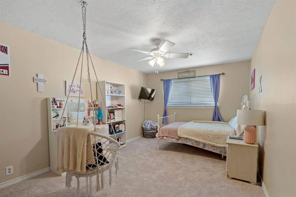 Another view of the Second bedroom features neutral walls, new carpet, and a ceiling fan making it a versatile space for relaxation and study.