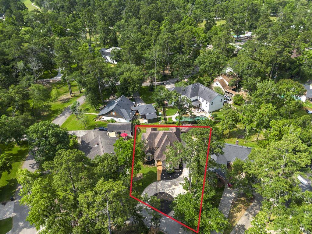 Notice the circular driveway, this house is nestled within a lush, wooded neighborhood. The property features a spacious, tree-lined driveway, offering seclusion and natural beauty. The surrounding area is serene, with neighboring homes and abundant greenery, ideal for privacy and tranquility.