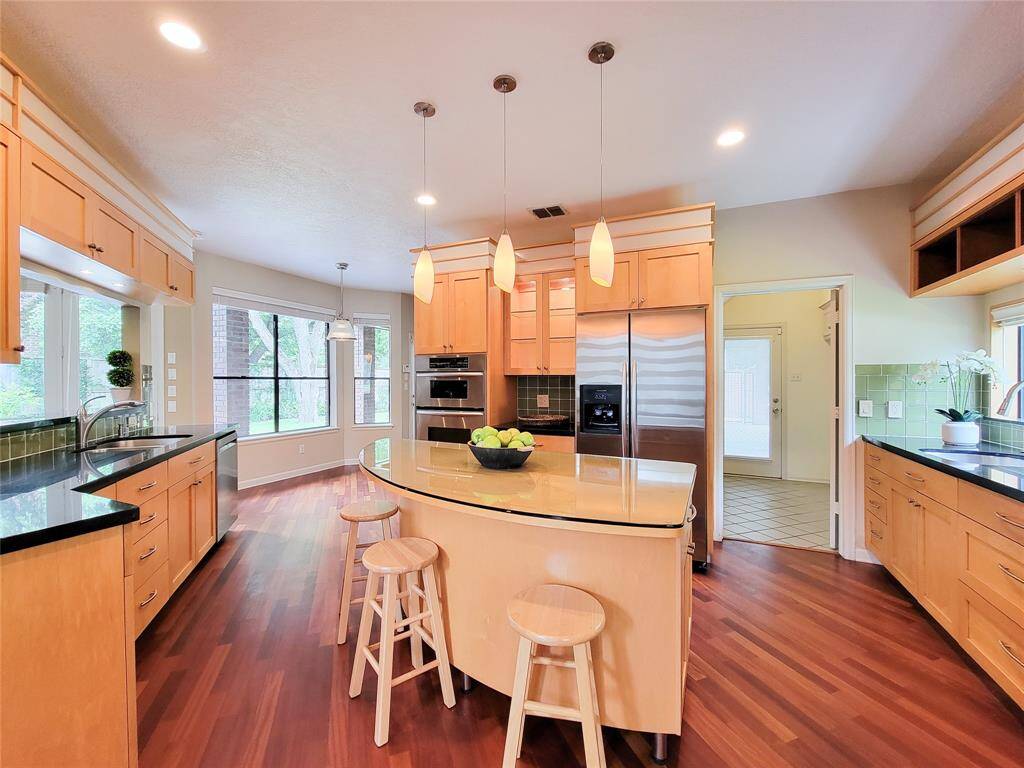 A chef’s dream! This beautifully updated kitchen boasts a stylish curved island, built-in oven and microwave for effortless meal prep, a sleek side-by-side stainless refrigerator, and a newly installed stainless steel dishwasher.