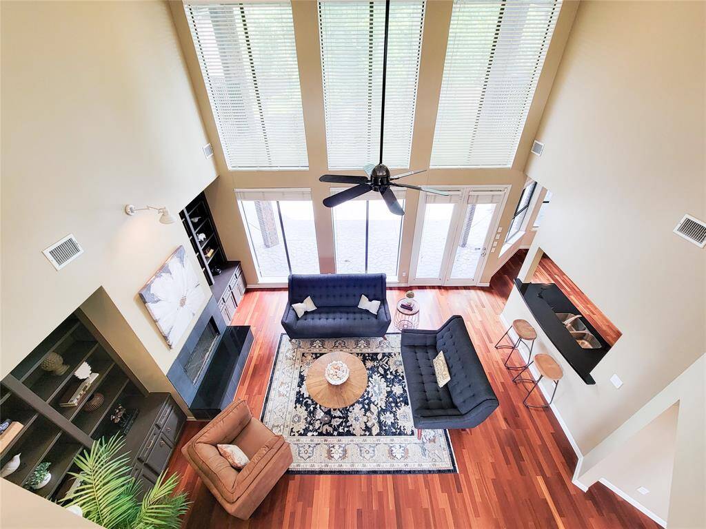 Elegant open-concept living room as seen from the second-floor loft—soaring ceilings, stylish finishes, and a perfect blend of warmth and sophistication.