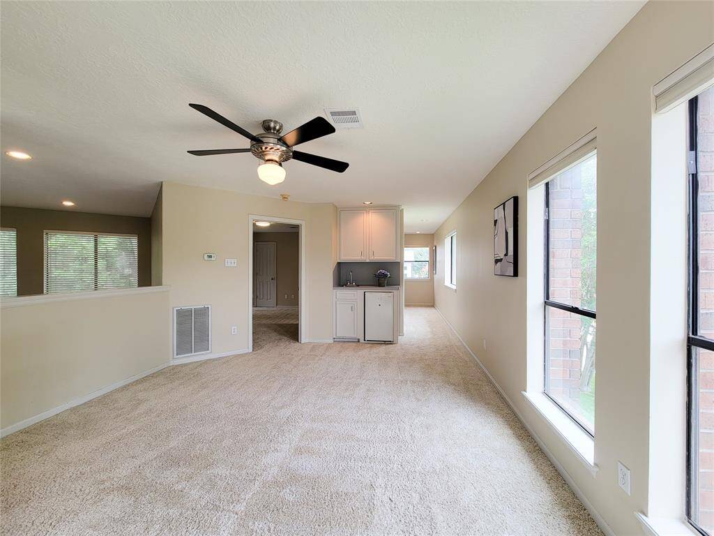 Game room with refrigerator and bar area. The door straight ahead is one of the three upstairs bedrooms, each with their own private balcony door.