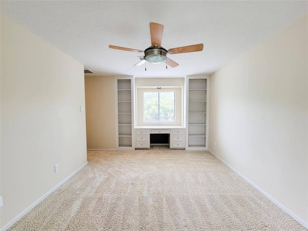 The third of the upstairs secondary bedrooms, with built-in book shelves and desk.