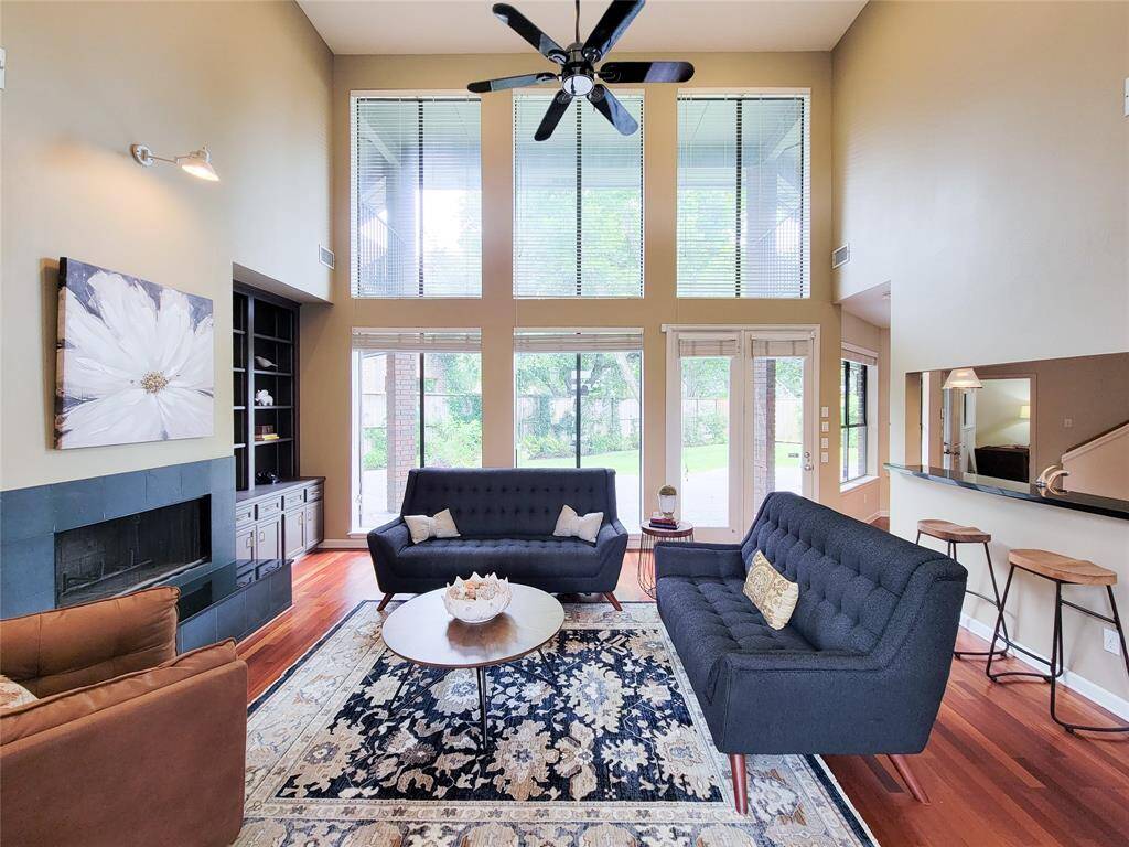 Living room with expansive wall of windows and breathtaking soaring 19 foot ceilings seamlessly merge indoor elegance with the beauty of the outdoors—where natural light and stunning views become part of the home.