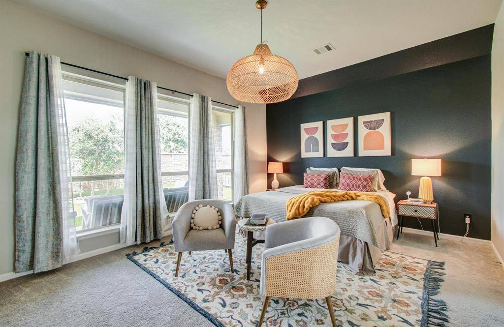 The luxurious primary bath is a spa-like retreat, complete with dual vanities, a garden tub, a separate glass-enclosed shower, and an oversized walk-in closet, offering both functionality and elegance.