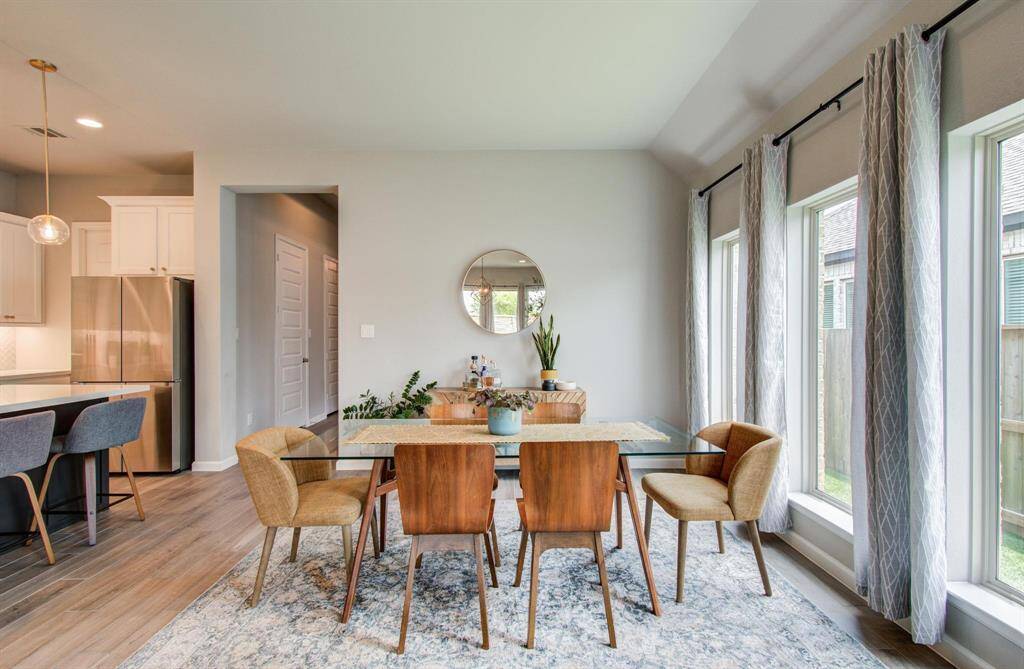The expansive family room is designed for comfort and style, featuring a wall of windows that bathe the space in natural light, creating a warm and inviting atmosphere.