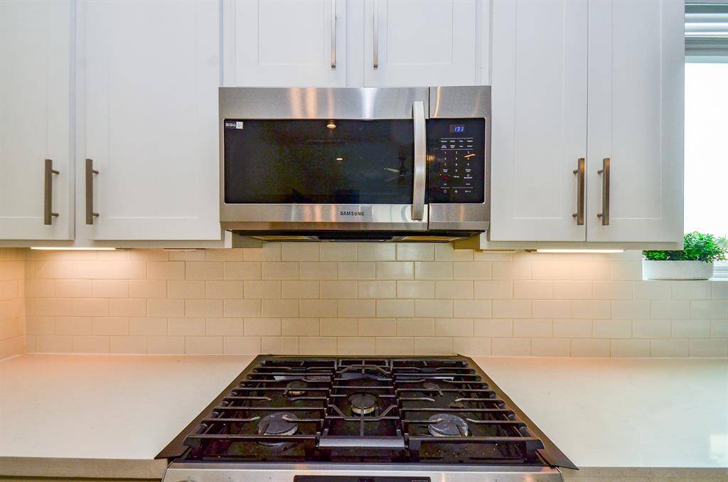 White counter space and pale tile backsplash are practical and also easy on the eyes!