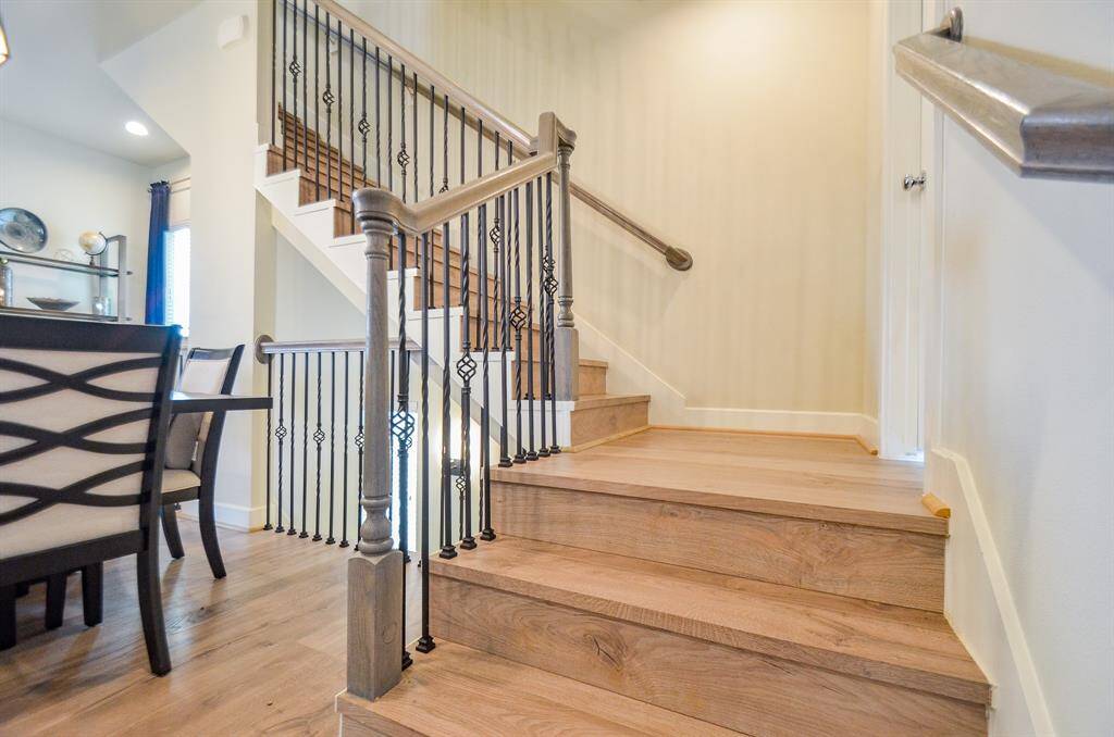 Attractive wrought iron/wood stair railings are the finishing touch on the beautiful staircase going to the third floor. The half bath is located to the door on the right.