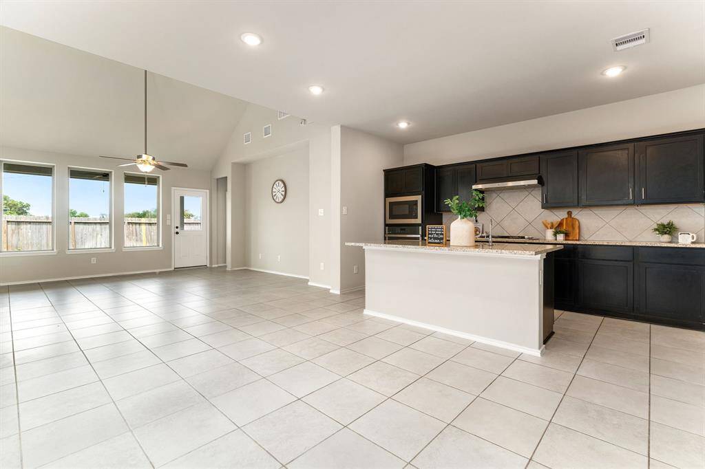 Open-concept layout with natural light flowing through the kitchen and family room.