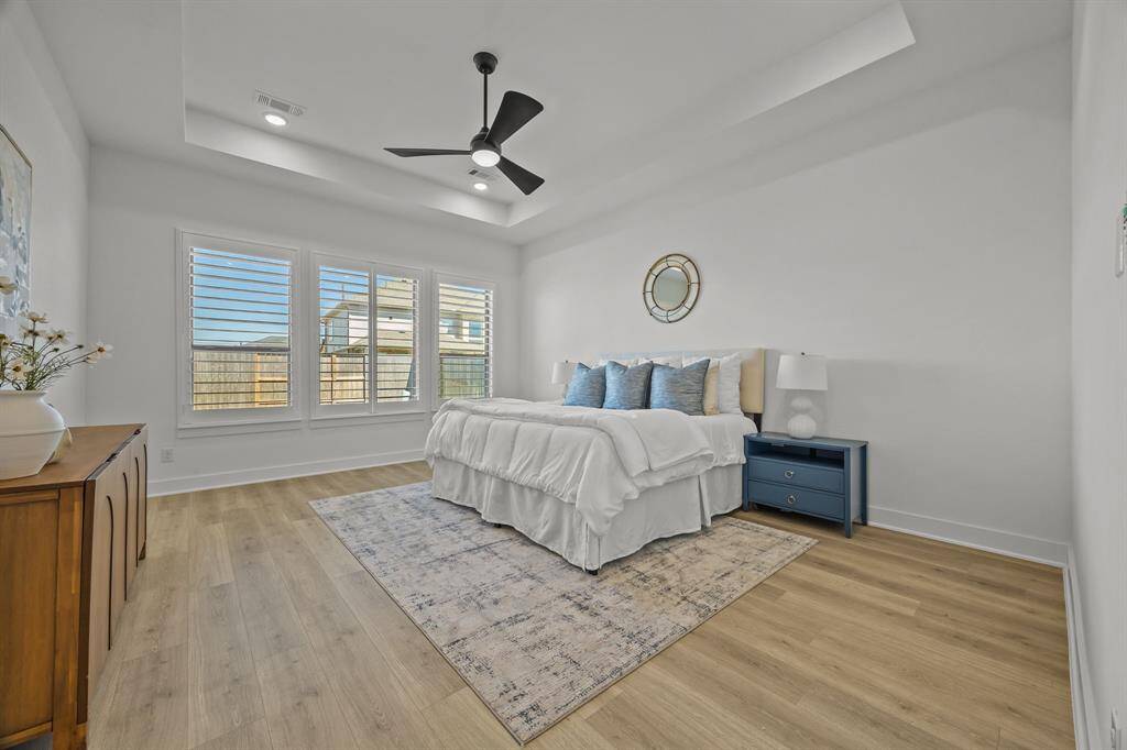 The owner’s retreat features a tray ceiling, plantation shutters, and sleek modern finishes.