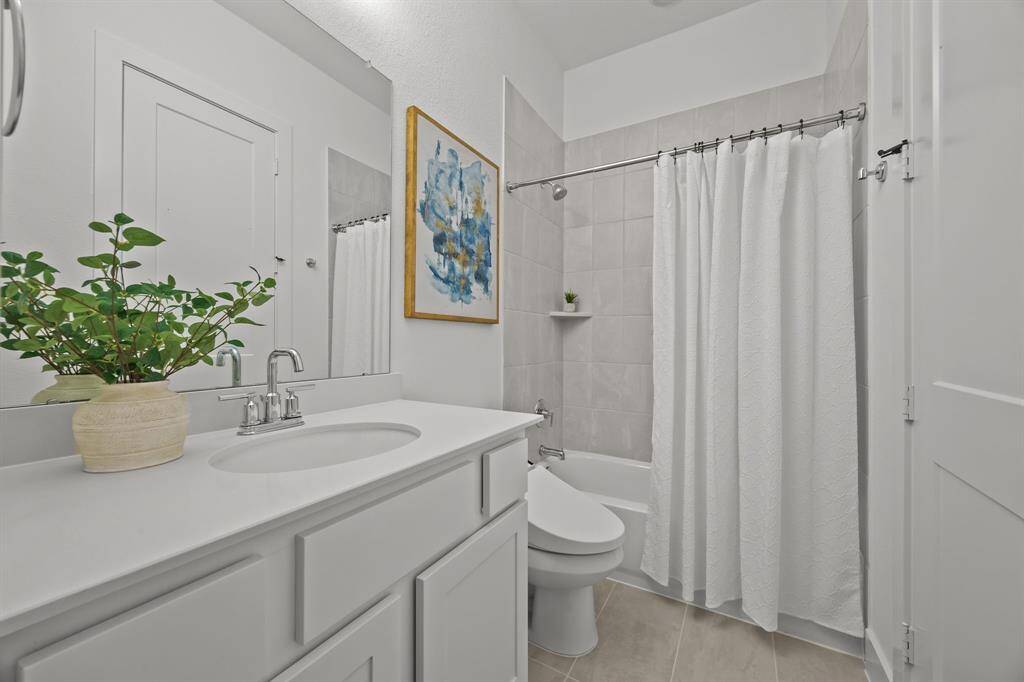 This en-suite bathroom offers a walk-in closet and a convenient tub-shower combination.