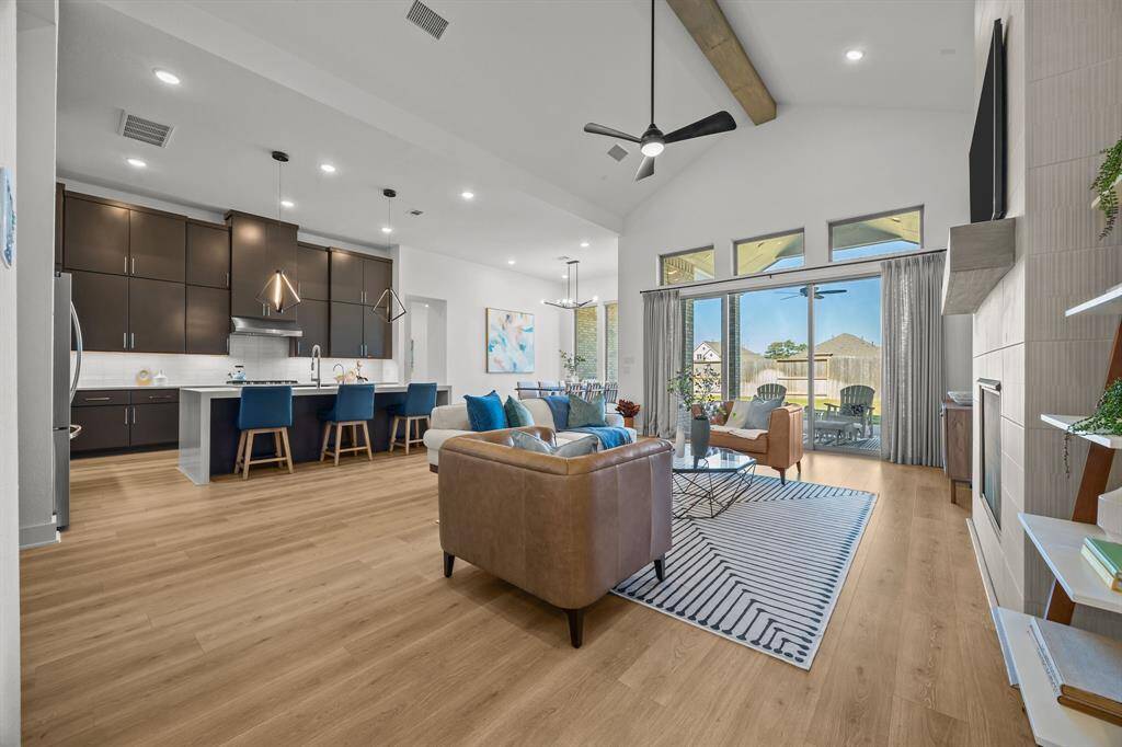 This completely show stopping, jaw dropping main living space features a custom beamed vaulted ceiling, an expansive sliding glass wall and a modern, sleek floor-to-ceiling fireplace.
