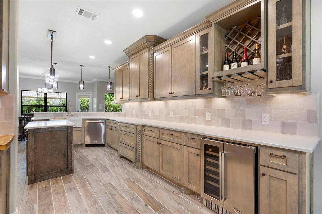 The ultimate host's dream! This stunning custom kitchen features a luxurious island with ample storage, elegant pendant lighting, and a spacious entertaining area with a breakfast bar, perfect for gatherings.