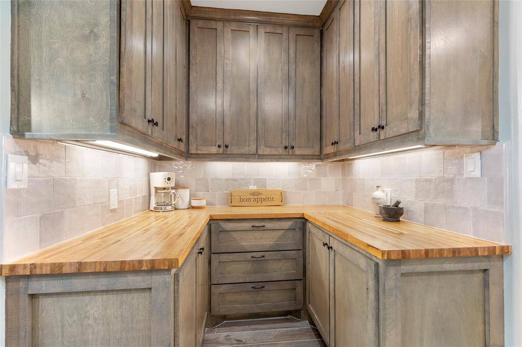 Custom butcher block counters, food and appliance storage, and under-cabinet lighting to showcase the warm zellige tile - what more could a host possibly need in a kitchen?