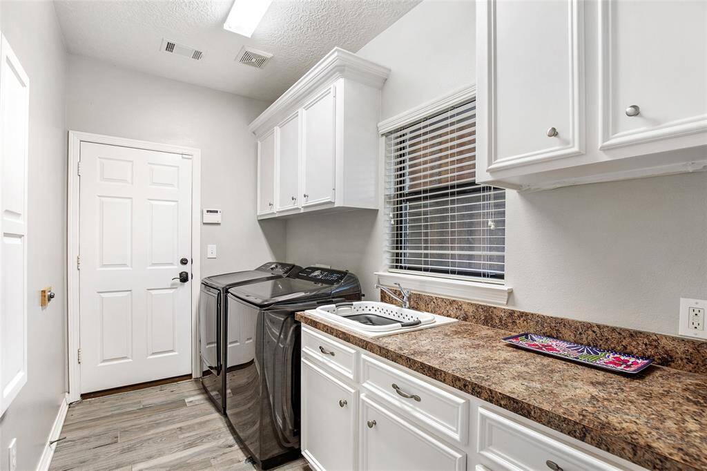 Functional meets stylish – a bright laundry room with ample storage and counter space for all your needs.