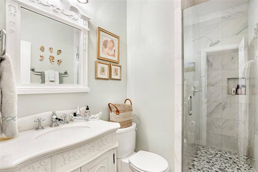 Luxurious and spacious – a modern bathroom with a glass shower, deep soaking tub, and elegant chandelier lighting.