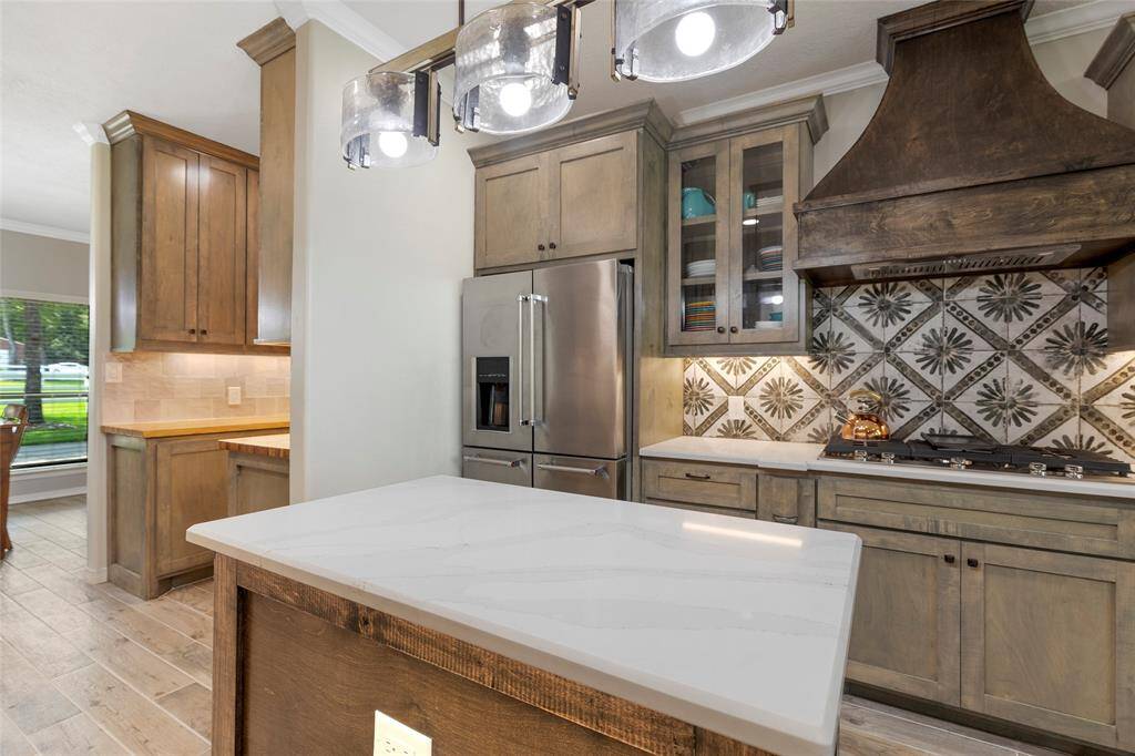 The custom hood range over an inviting, yet warm backsplash will make any party a crowd pleaser.