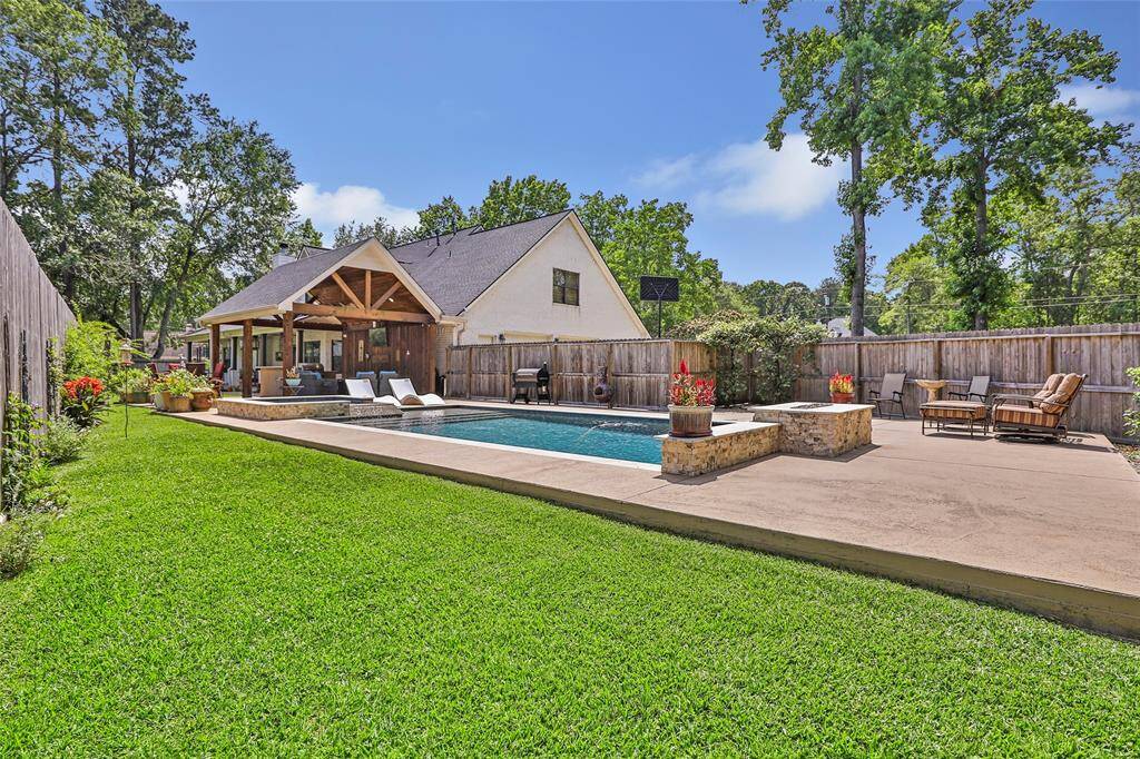This oversized backyard holds a custom pool, hot tub, entertaining area, and still leaves room for plants and pets. Country living on just under an acre!