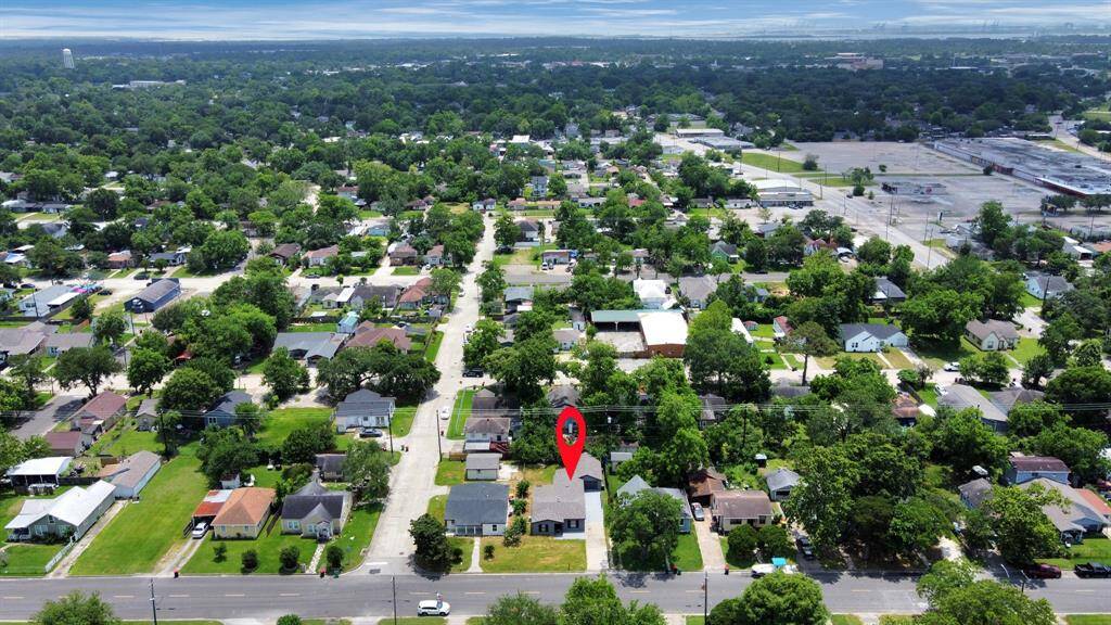 This aerial photo showcases a charming residential neighborhood with tree-lined streets and well-maintained houses. The highlighted property is centrally located with convenient proximity to amenities and green spaces, perfect for a home buyer seeking a community feel.