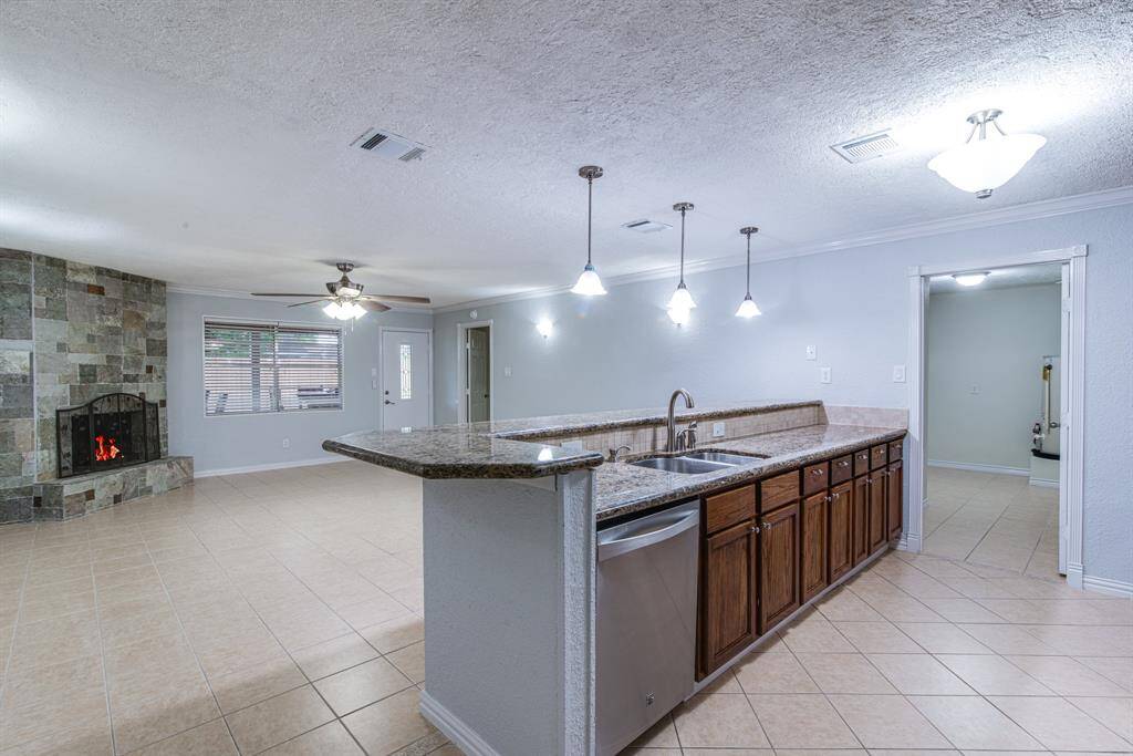 Open-concept kitchen and living area, complete with a stylish bar--perfect for entertaining or casual dining!