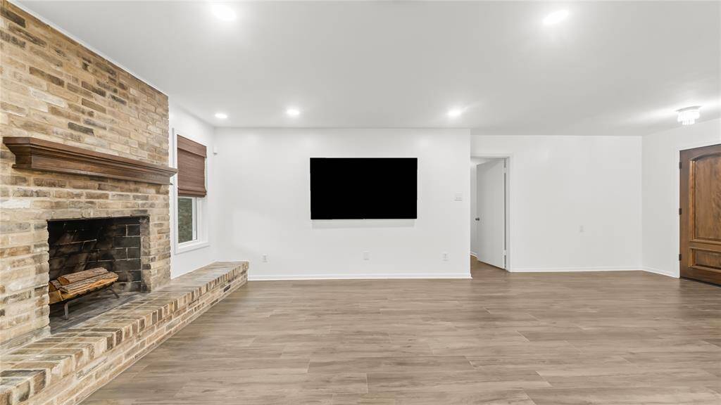 A wood burning brick fireplace with mantle anchors the living room, adding much character.