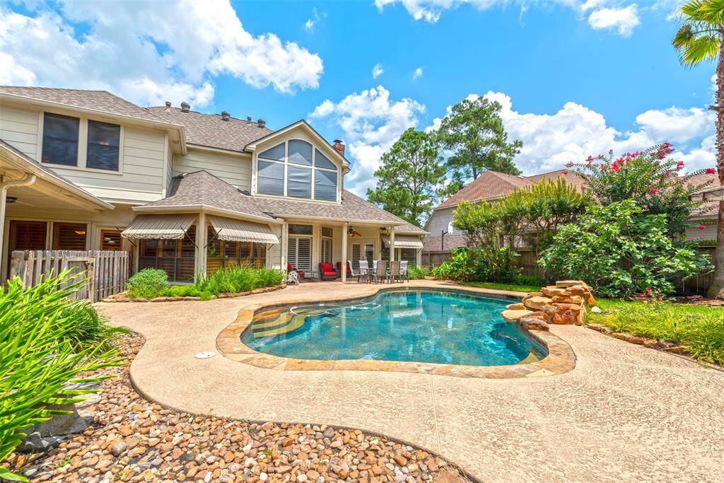 Spacious backyard features a sparkling pool with a tranquil waterfall feature, perfect for relaxing or entertaining.