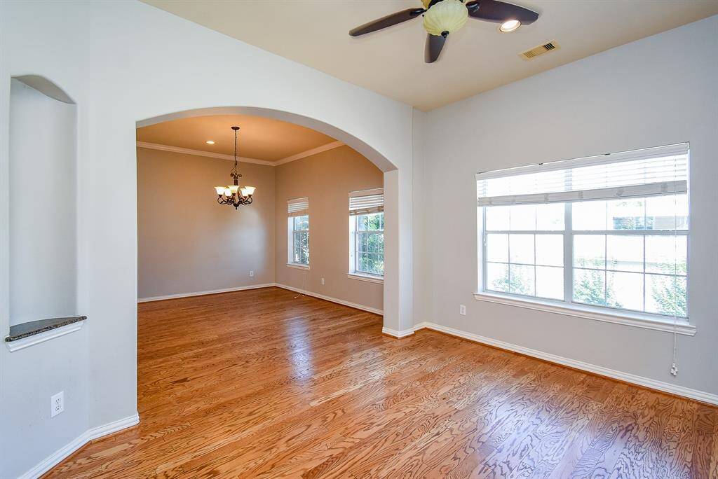 Bright, open living space with hardwood floors, large windows, and elegant light fixtures. Ideal for entertaining and relaxation.