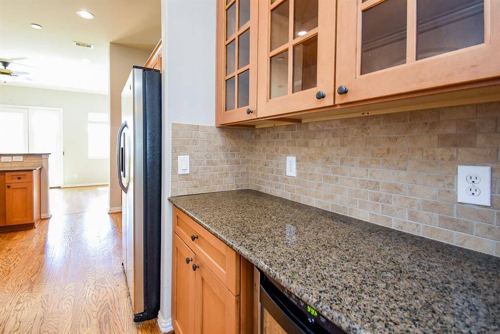 Bright and open living area with hardwood floors and a cozy fireplace. Natural light streams through the windows and glass door, enhancing the airy feel.