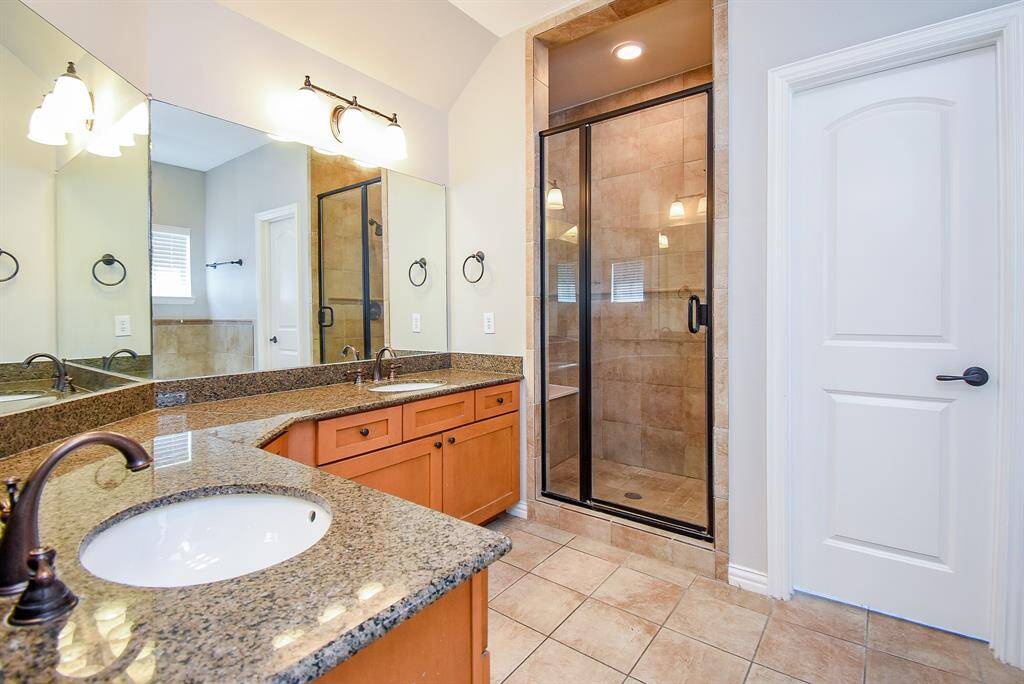This bathroom features a cozy corner jetted tub with beige tile surround and a convenient window for natural light.
