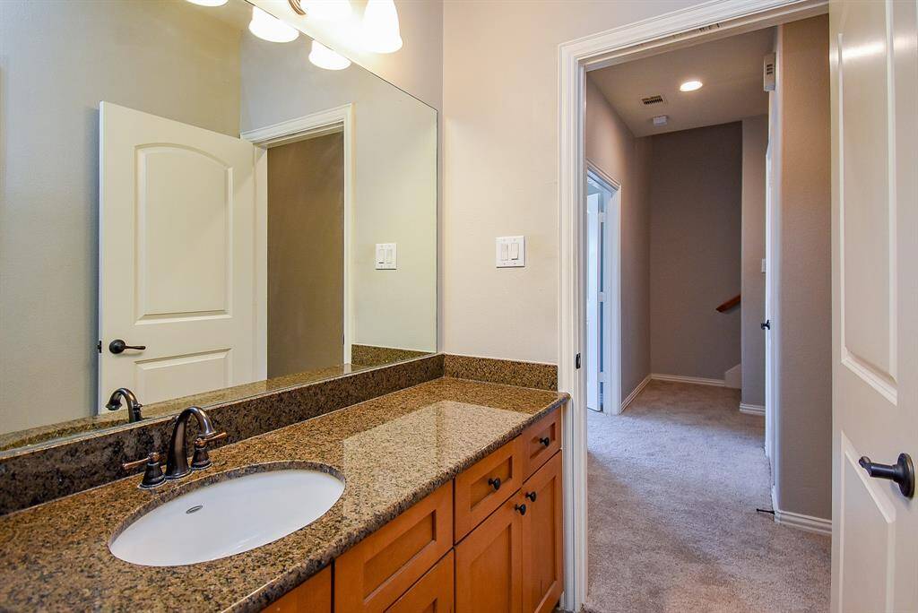 This photo shows a laundry area with a washer and dryer set beneath wooden cabinets.