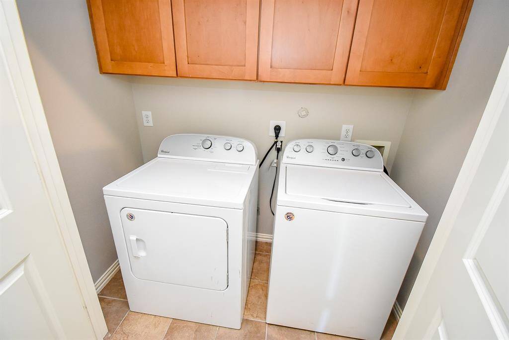 Bright study on first floor with new flooring, a ceiling fan, and French doors leading to the outside. Includes a built-in desk and adjacent bathroom with a tiled bath. Ideal for a home office or cozy living space.