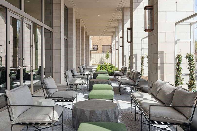 Serene outdoor lounge featuring comfortable seating and lush greenery, perfect for relaxation and entertaining.