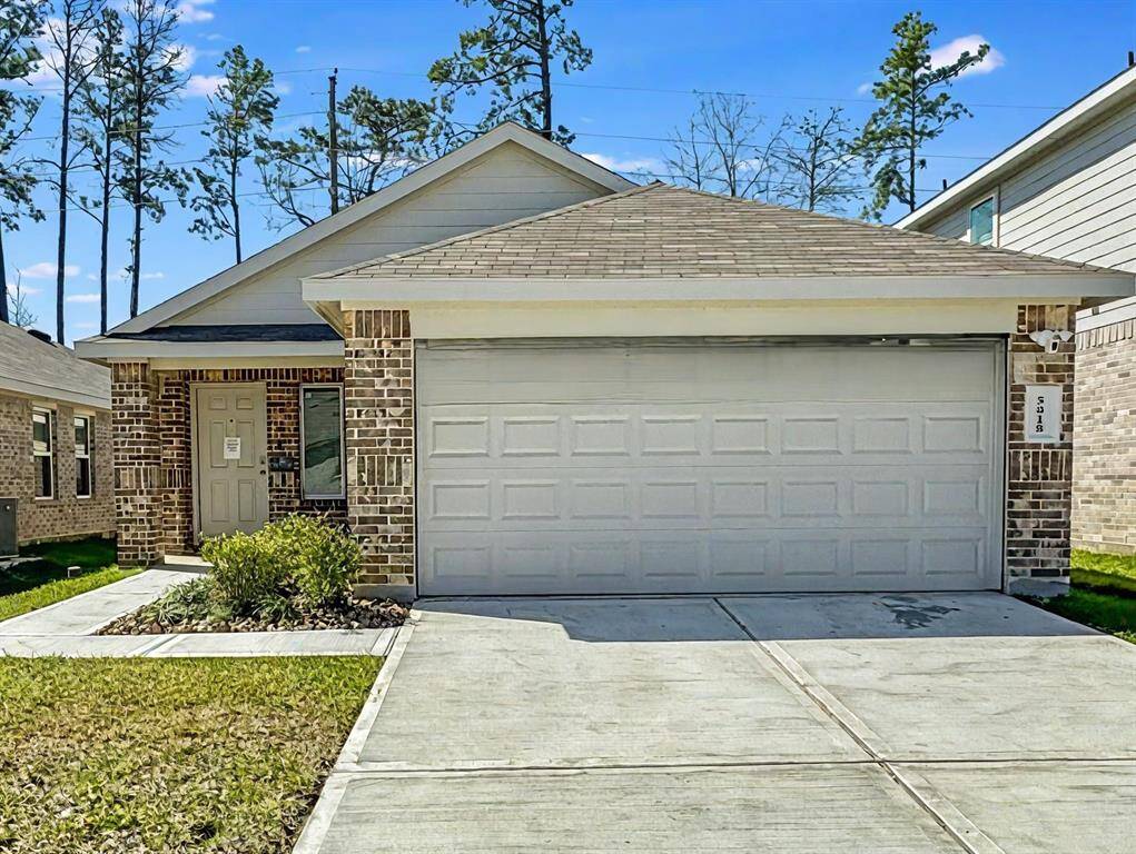 Charming single story brick home with a welcoming front porch. Features a neat garden bed with shrubs and stones lining the walkway.