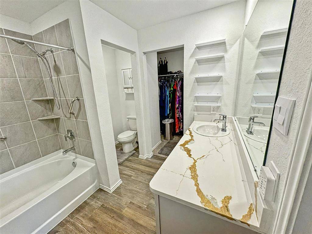 Large vanity counterop with built in shelving provides generous storage and space