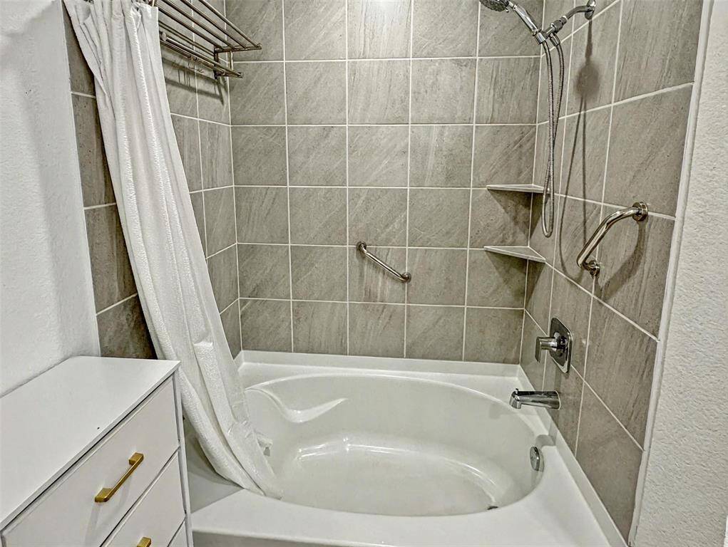 right and spacious bathroom featuring a large vanity with elegant quartz countertops, ample