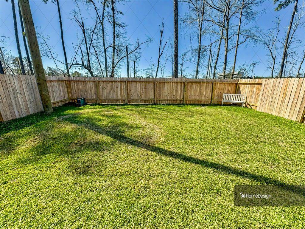 Spacious backyard with well-maintained lawn, surrounded by a wooden fence for privacy. Perfect for outdoor activities and relaxation.