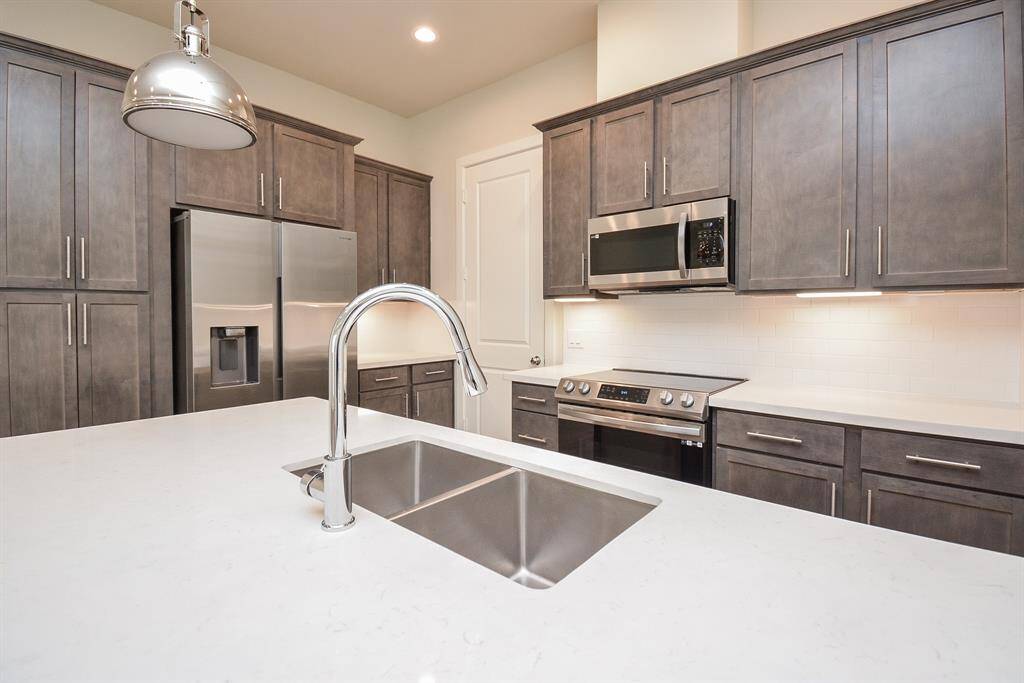 Perfect for cooking enthusiasts, this kitchen has everything you need – from shaker cabinetry and quartz countertops to high-end appliances.