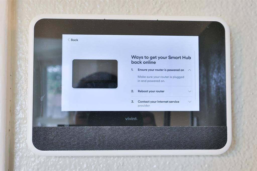 This photo shows a smart home hub interface mounted on a wall, displaying troubleshooting steps to reconnect the device online. It's a modern feature for controlling home automation systems.