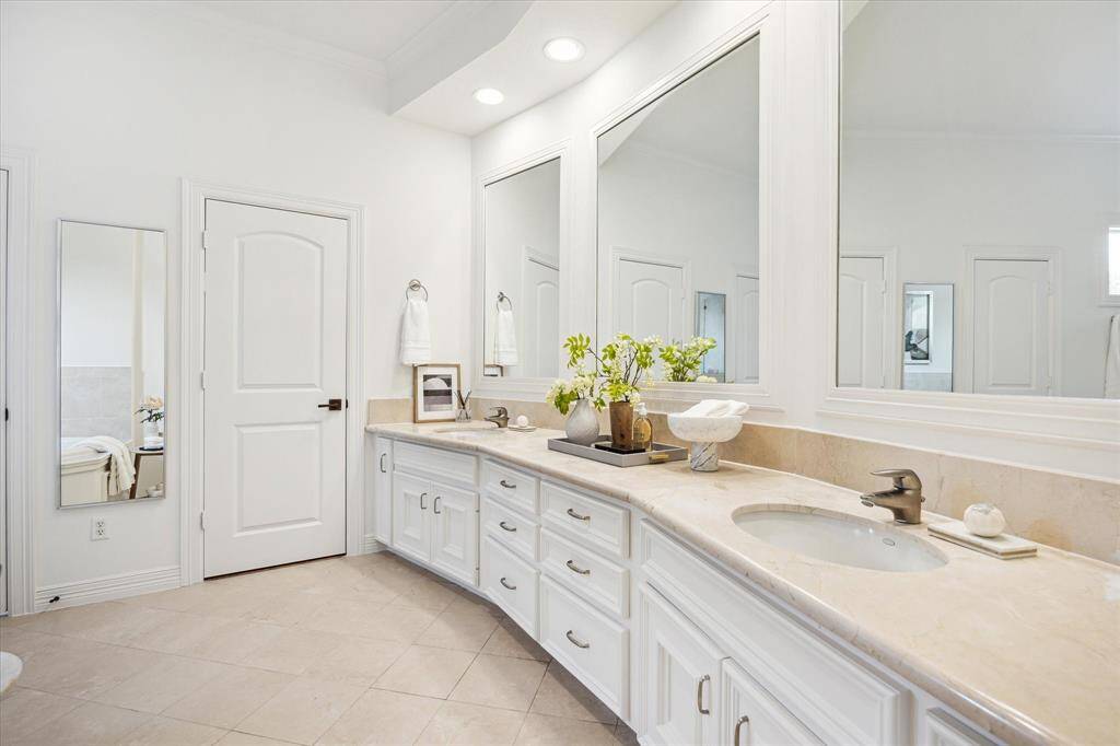 [Primary Bath] Marble-clad primary bath features dual sinks, two spacious closets and extra counter space.