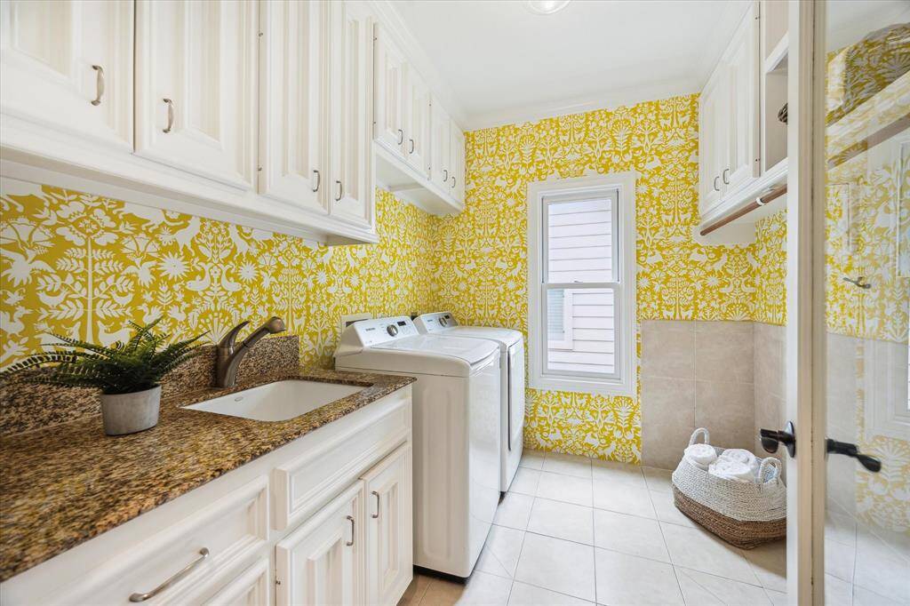 [Utility Room] Light and bright utility room with wallpaper. Large deep sink, cabinet, drawers. Dedicated hanging space. The storage here is generous.
