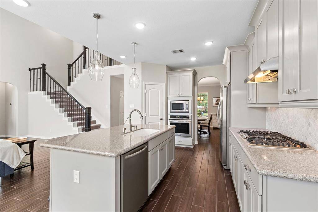 A stainless steel appliance suite and gas cooktop with vent hood await the chef in the household. If meal prep is a group effort, there is plenty of space in this well-designed plan for more than one cook to be in the kitchen. The island orientation means you never have to miss out on the fun while you are in the kitchen...you have open sight lines to the living room, dining room, and even to the backyard from your sink and stove.