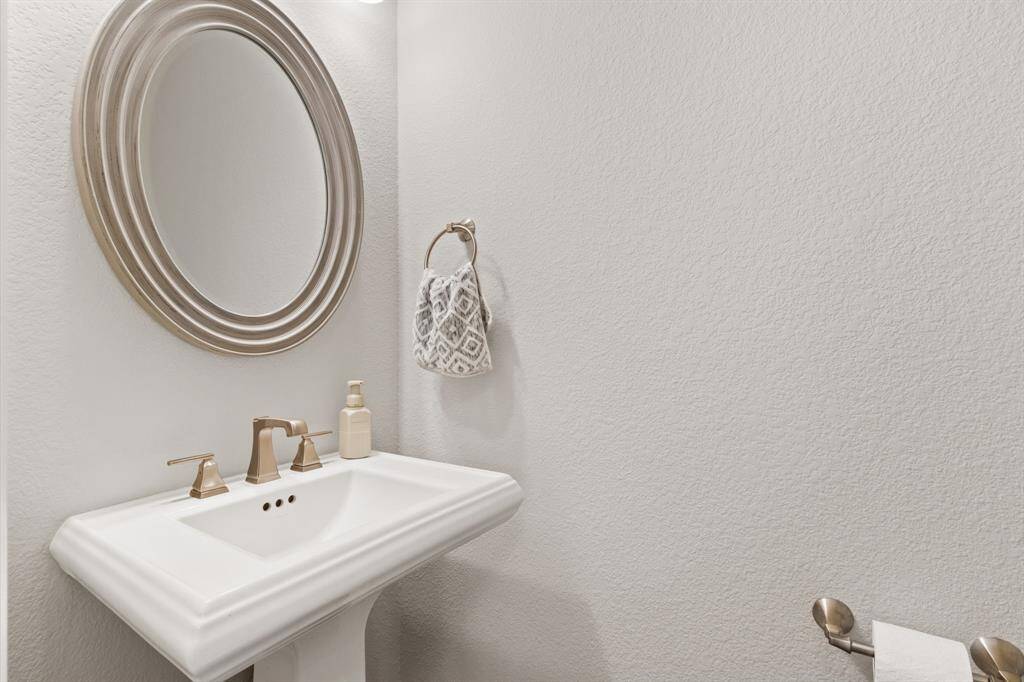 The downstairs powder room with upgraded fixtures provides privacy for guests and residents alike.