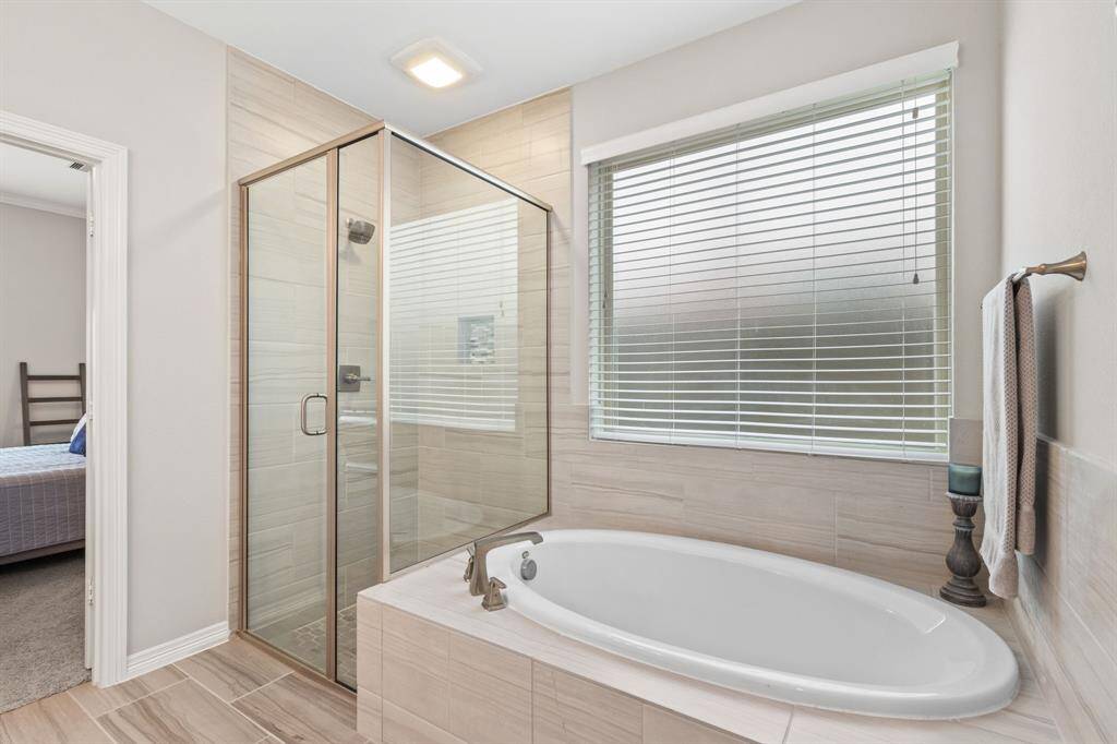 Whether you prefer a long soak at the end of the day, or a quick shower before you head out in the morning, the primary bath has you covered! Privacy glass provides natural light without sacrificing modesty in this private space within your primary suite.