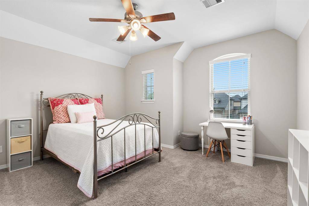 Bedroom 3 overlooks the front yard. Each of the secondary bedrooms features a walk-in closet and ceiling fan with lights.