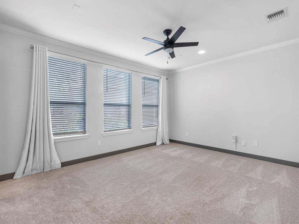 Bedroom 4 features soft carpet, neutral walls, and ample natural light from three large windows with blinds and curtains. It includes a modern ceiling fan, recessed lighting, and is perfect as a cozy bedroom or an office.