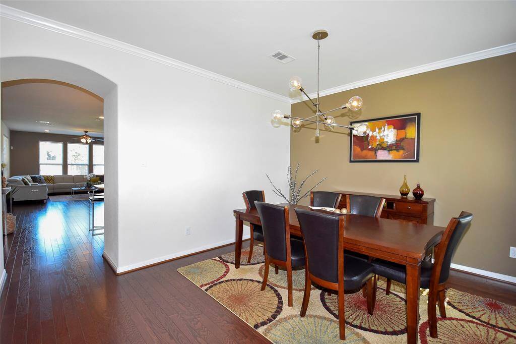 Formal dinning room with modern chandelier and hardwood floors throughout the first floor.