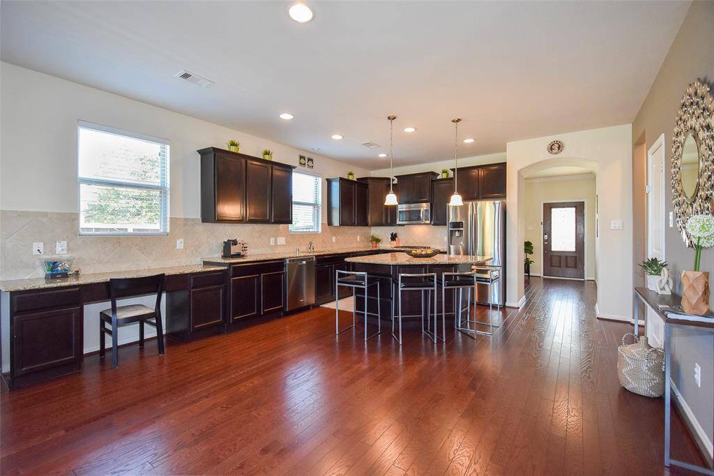 Open concept kitchen with plenty of storage cabinets, granite countertops, Stainless Steel appliances, and seating space around the island.
