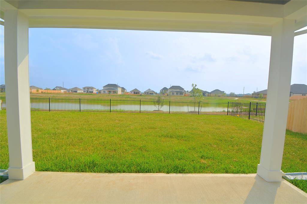 The backyard view of the lake! Featuring a covered patio, perfect for enjoying the outdoors!