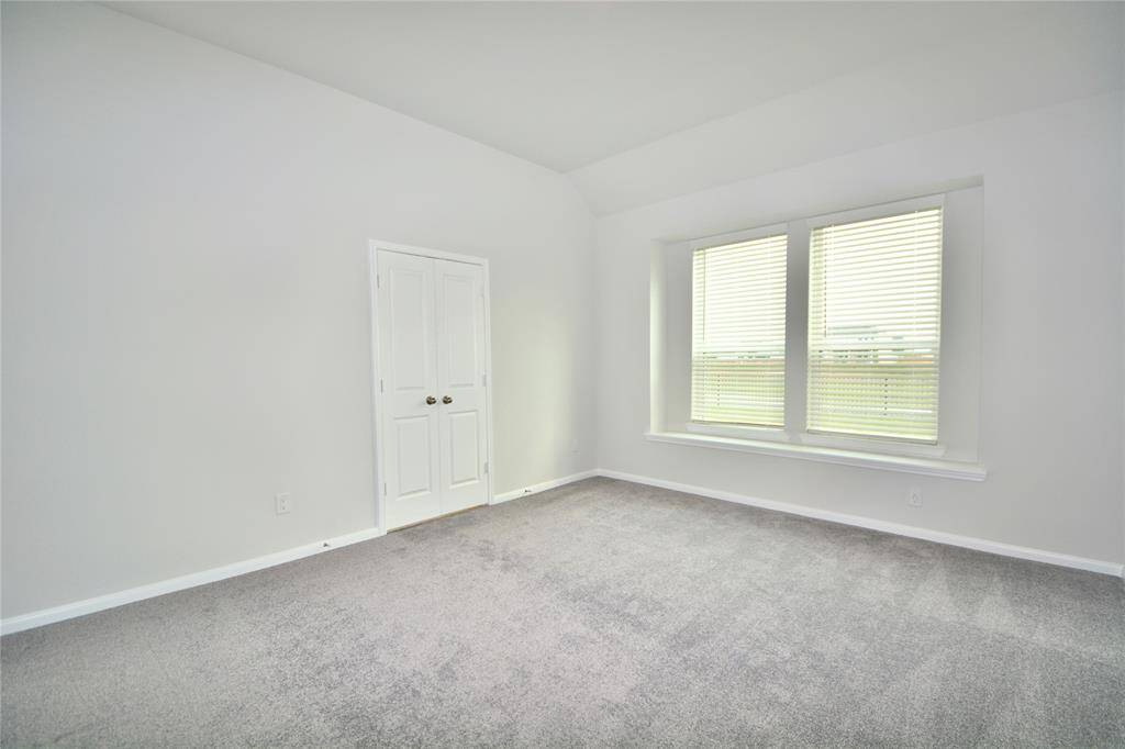 A view of the primary bedroom featuring high ceilings!