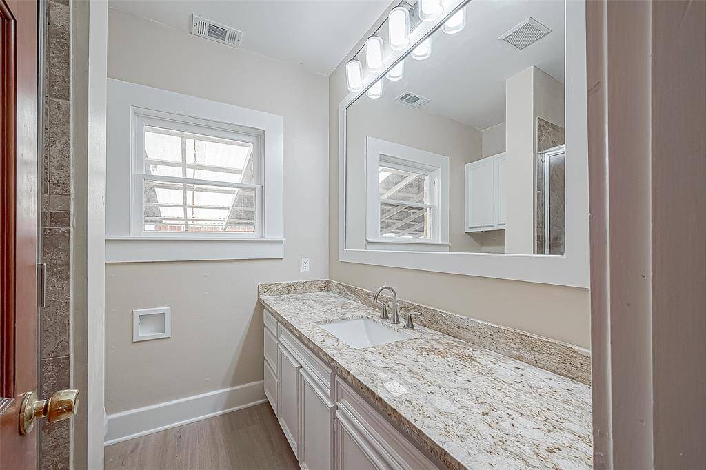 Both downstairs bedrooms share this remodeled full bath, with a long countertop and great storage space.