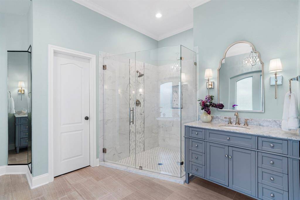 There are dual vanities and the walk-in shower features tile surround and glass door.